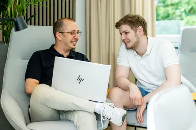 Zwei Personen gucken auf einen Laptop
